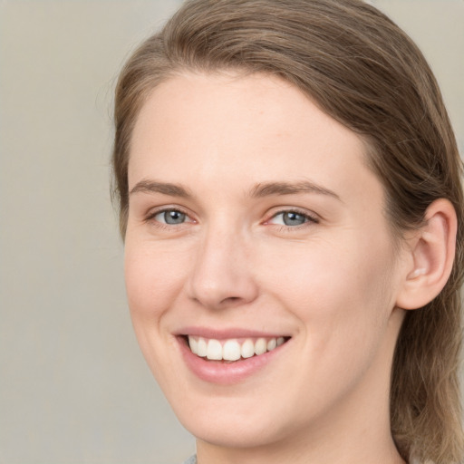 Joyful white young-adult female with medium  brown hair and grey eyes