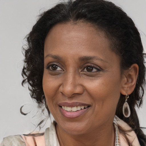 Joyful black adult female with long  brown hair and brown eyes