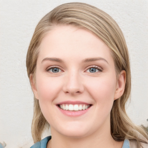 Joyful white young-adult female with long  brown hair and blue eyes