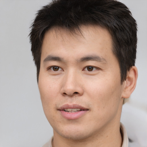 Joyful asian young-adult male with short  brown hair and brown eyes