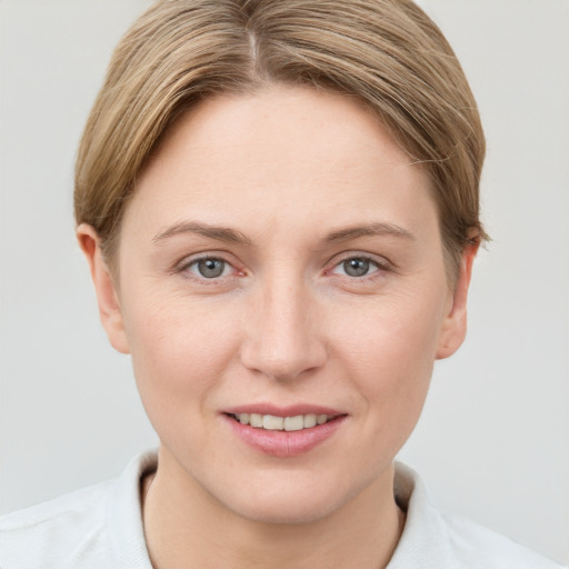 Joyful white young-adult female with short  brown hair and grey eyes