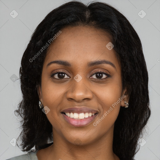 Joyful black young-adult female with long  black hair and brown eyes