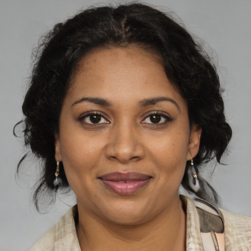 Joyful black adult female with medium  brown hair and brown eyes