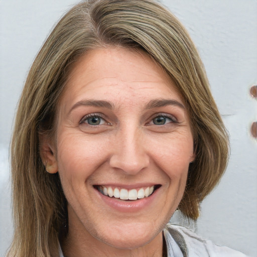 Joyful white adult female with medium  brown hair and green eyes