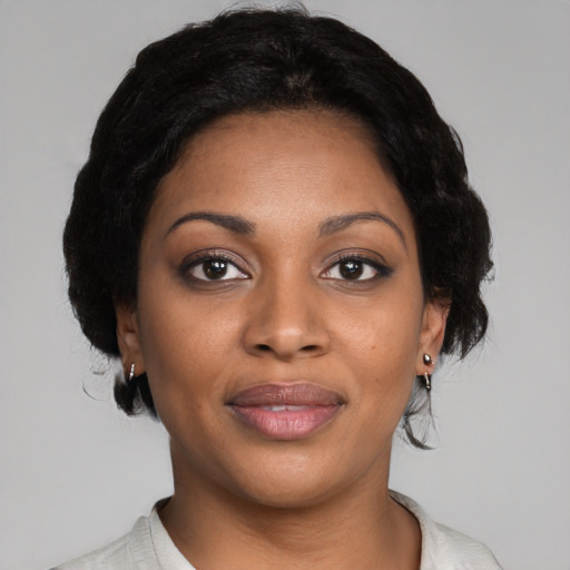 Joyful black young-adult female with short  black hair and brown eyes