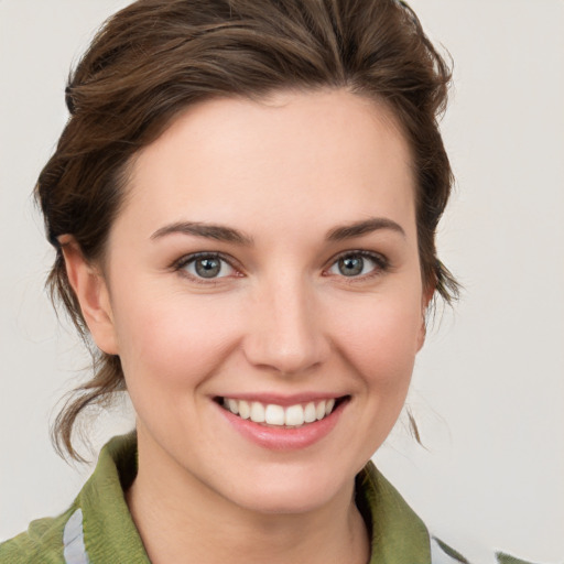 Joyful white young-adult female with medium  brown hair and green eyes