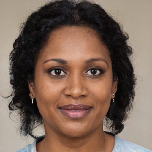 Joyful black adult female with medium  brown hair and brown eyes