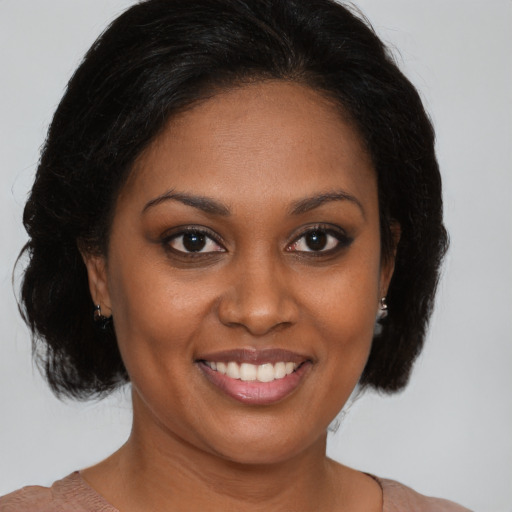 Joyful black young-adult female with medium  brown hair and brown eyes