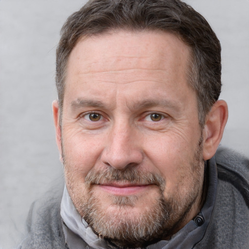 Joyful white adult male with short  brown hair and grey eyes