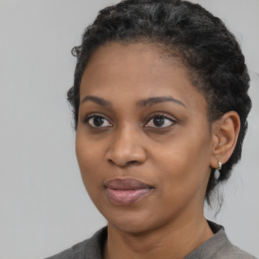 Joyful black young-adult female with medium  black hair and brown eyes
