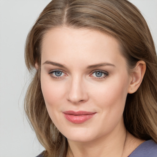 Joyful white young-adult female with long  brown hair and blue eyes