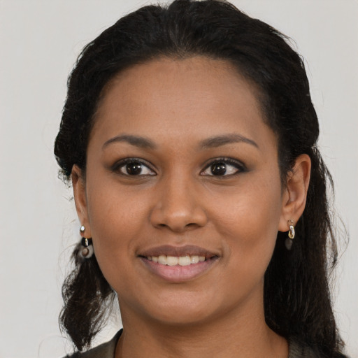 Joyful black young-adult female with long  black hair and brown eyes