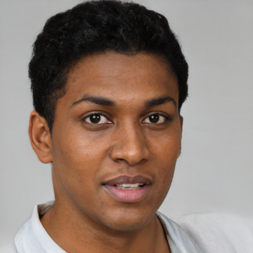 Joyful black young-adult male with short  black hair and brown eyes