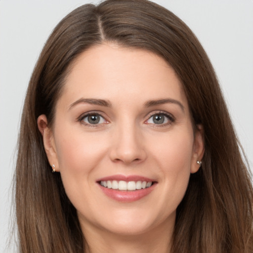 Joyful white young-adult female with long  brown hair and grey eyes