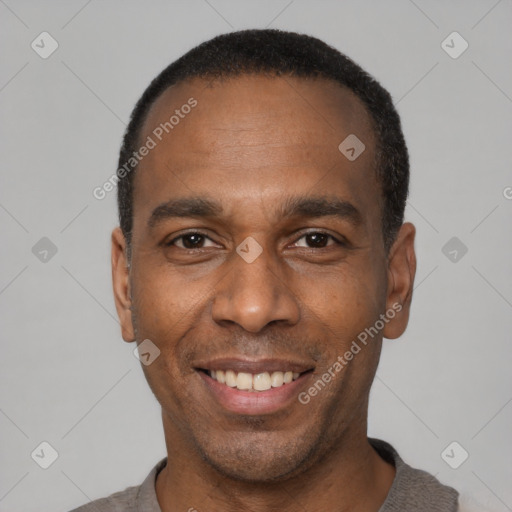 Joyful black adult male with short  black hair and brown eyes