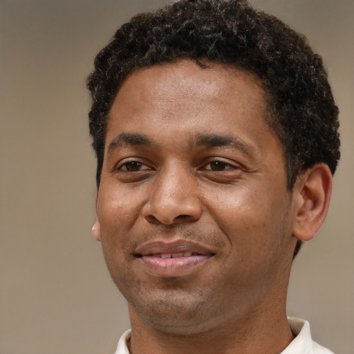 Joyful black adult male with short  brown hair and brown eyes