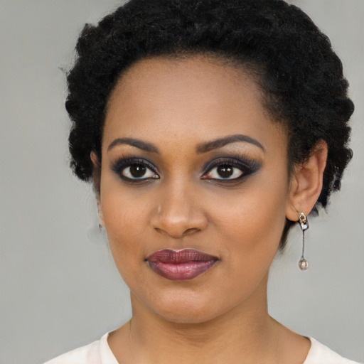 Joyful black young-adult female with short  black hair and brown eyes