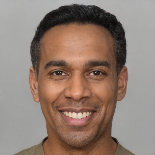 Joyful latino adult male with short  black hair and brown eyes