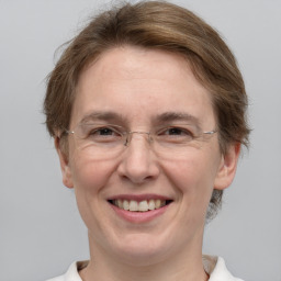 Joyful white adult female with medium  brown hair and grey eyes