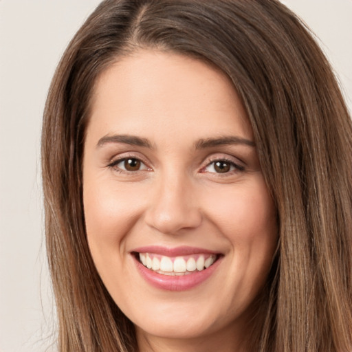 Joyful white young-adult female with long  brown hair and brown eyes