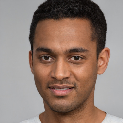 Joyful black young-adult male with short  black hair and brown eyes