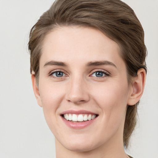 Joyful white young-adult female with medium  brown hair and green eyes