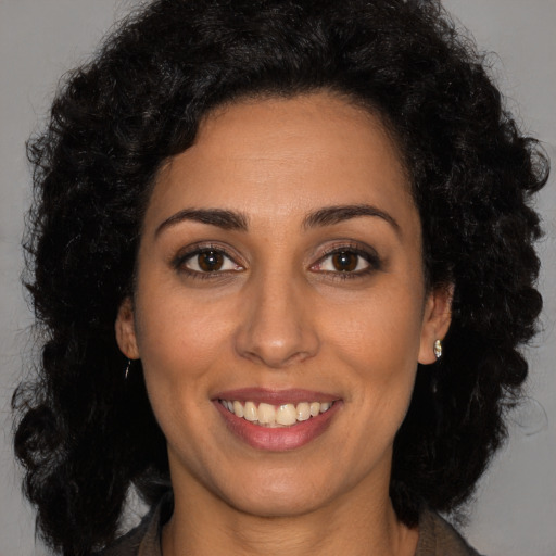 Joyful latino young-adult female with long  black hair and brown eyes