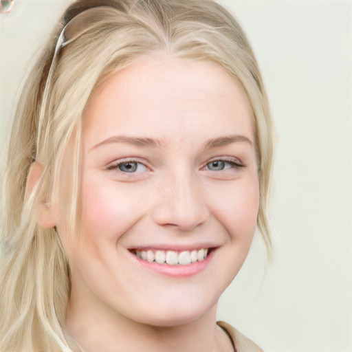 Joyful white young-adult female with long  blond hair and blue eyes