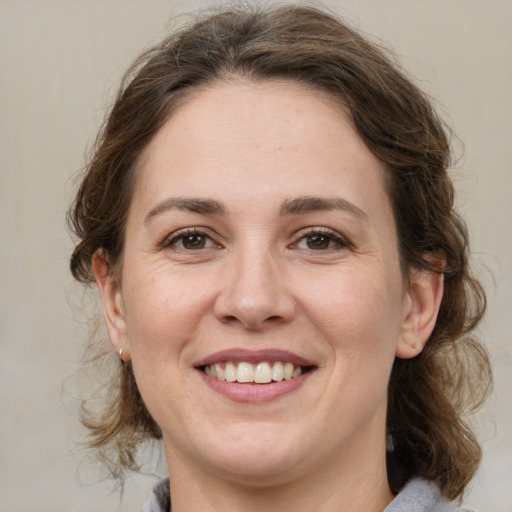 Joyful white adult female with medium  brown hair and brown eyes