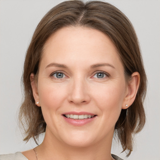 Joyful white adult female with medium  brown hair and grey eyes