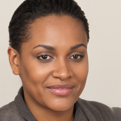 Joyful black young-adult female with short  brown hair and brown eyes