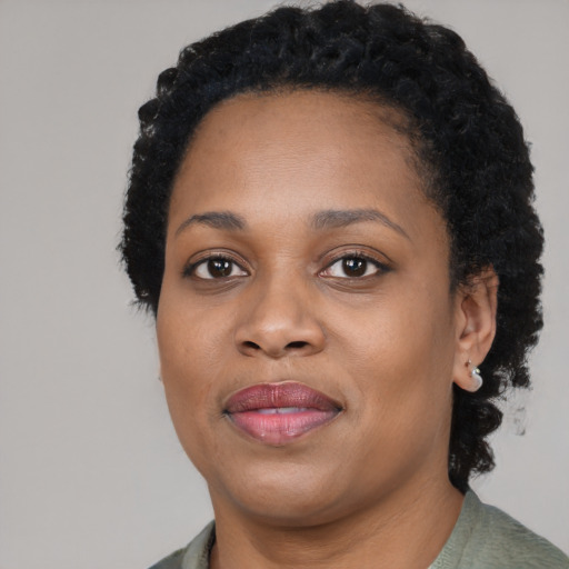 Joyful black young-adult female with short  black hair and brown eyes