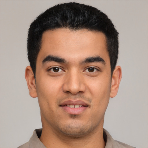 Joyful latino young-adult male with short  black hair and brown eyes