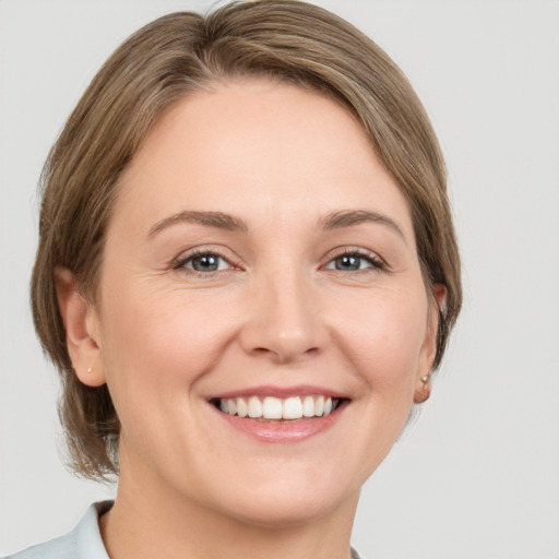 Joyful white adult female with medium  brown hair and grey eyes