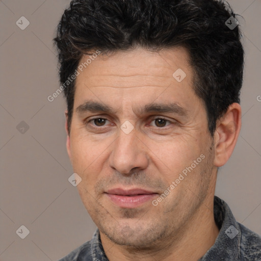 Joyful white adult male with short  black hair and brown eyes