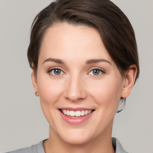 Joyful white young-adult female with short  brown hair and grey eyes