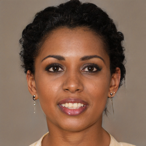 Joyful black young-adult female with short  brown hair and brown eyes