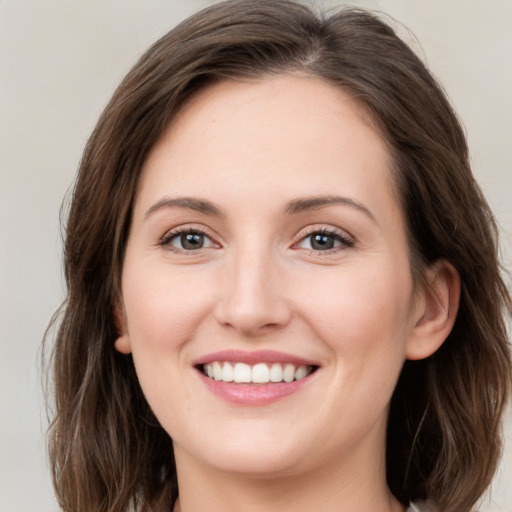 Joyful white young-adult female with medium  brown hair and green eyes