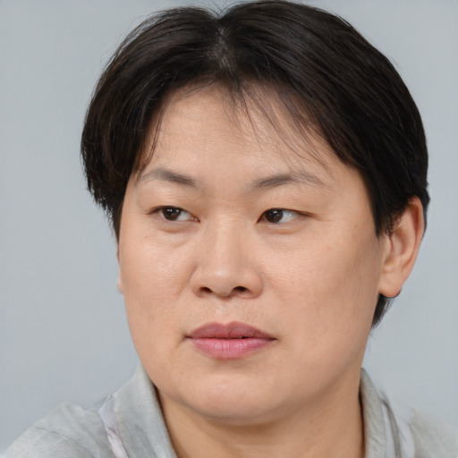 Joyful asian adult female with short  brown hair and brown eyes