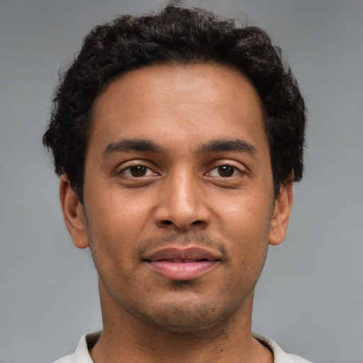 Joyful latino young-adult male with short  brown hair and brown eyes