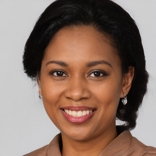 Joyful black young-adult female with long  brown hair and brown eyes