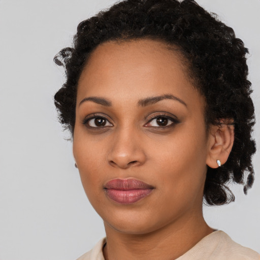 Joyful black young-adult female with medium  black hair and brown eyes