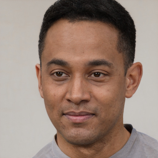 Joyful latino young-adult male with short  black hair and brown eyes