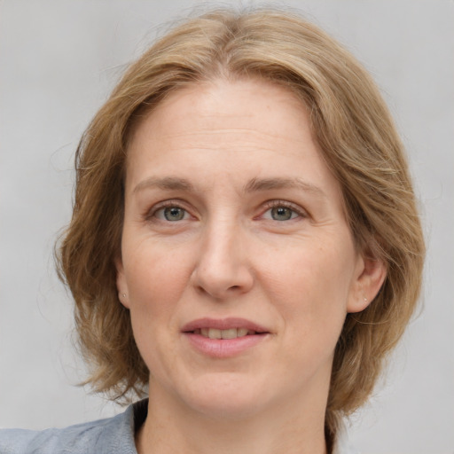 Joyful white adult female with medium  brown hair and blue eyes