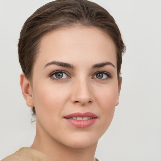 Joyful white young-adult female with short  brown hair and grey eyes