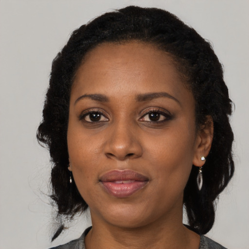 Joyful black adult female with medium  black hair and brown eyes