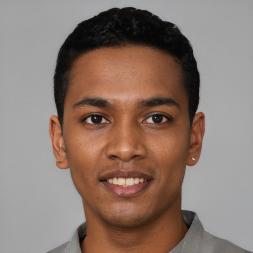 Joyful black young-adult male with short  black hair and brown eyes