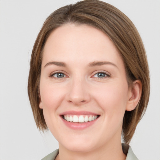 Joyful white young-adult female with medium  brown hair and green eyes