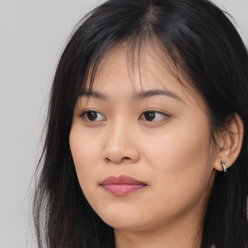 Joyful asian young-adult female with long  brown hair and brown eyes