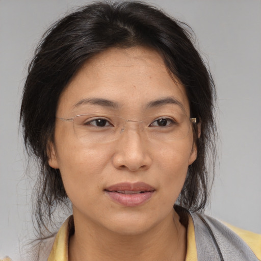 Joyful asian adult female with medium  brown hair and brown eyes